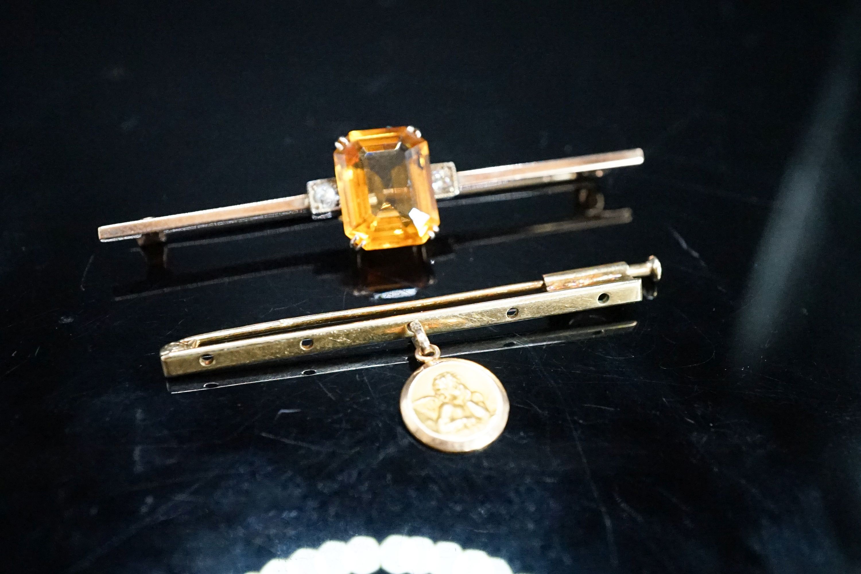 A yellow metal, single stone citrine and two stone diamond set bar brooch, 56mm and one other with cherub pendant charm, gross 6.3 grams.